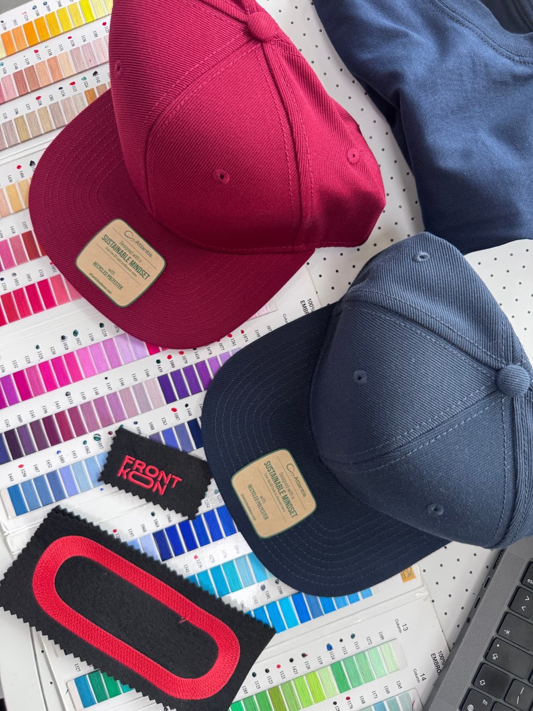 Frontkon#26 caps with embroidered patches next to thread swatches